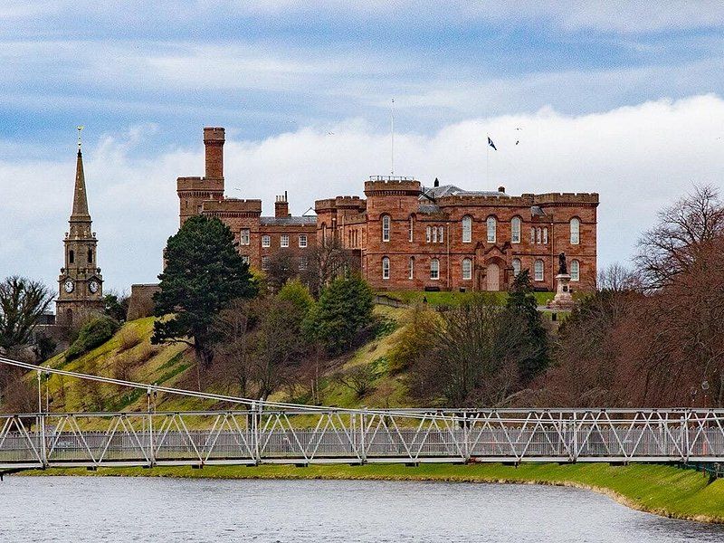 Inverness Castle seen across the River Ness from the suspension footbridge