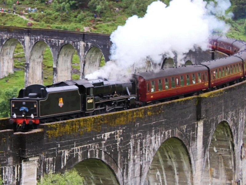 The Jacobite steam train working across the Glenfinnan Viaduct under full steam