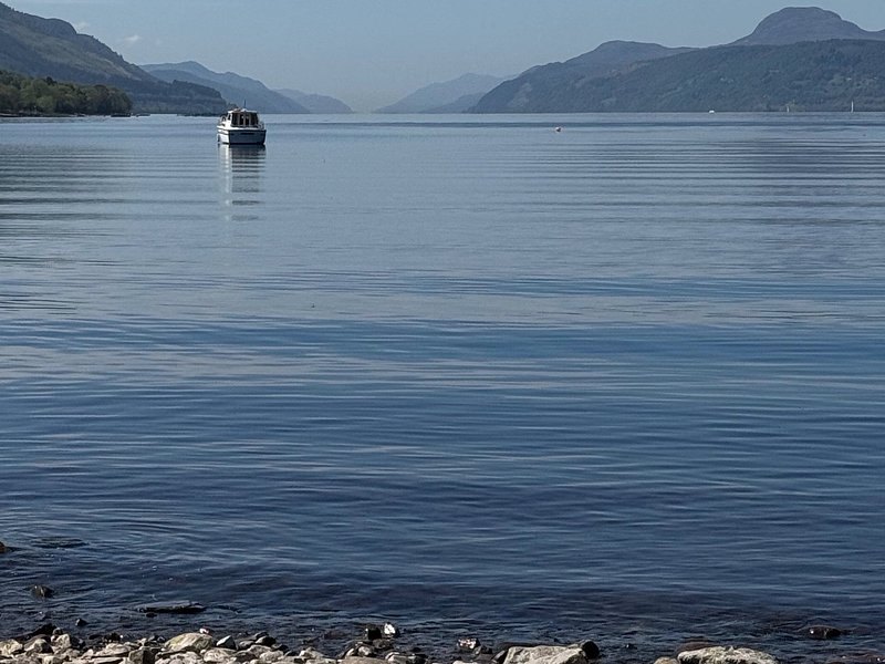 A cruise boat out on Loch Ness, with the hills of the Great Glen on both shores