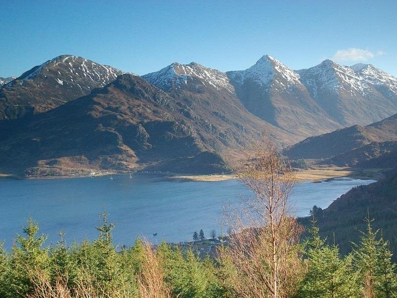 Snow lying on a high ridge above a Highland loch on a clear day