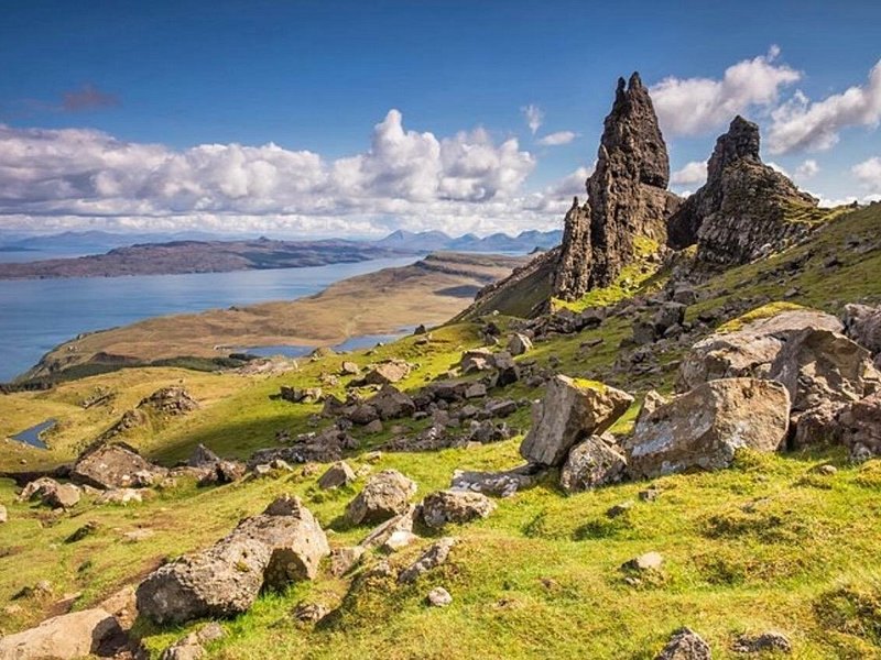 The rock pinnacle of the Old Man of Storr rising above the grass on Skye