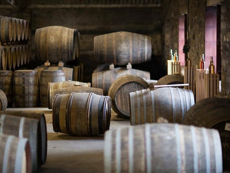 Oak casks stacked in the dunnage of a Highland distillery warehouse